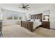 Bright main bedroom features neutral carpet, a ceiling fan, and sunny windows at 17226 Hickory Wind Dr, Clermont, FL 34711