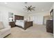 Bright main bedroom features neutral carpet, a ceiling fan, and an ensuite bathroom at 17226 Hickory Wind Dr, Clermont, FL 34711