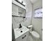 Modern bathroom featuring a sleek vanity, toilet, framed mirror, and marble-style tile at 2007 N Hastings St, Orlando, FL 32808
