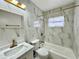 The bathroom features marble tiled walls, a shower-tub, and gold hardware at 2007 N Hastings St, Orlando, FL 32808