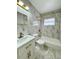 The bathroom features marble tiled walls, a shower-tub, and gold hardware at 2007 N Hastings St, Orlando, FL 32808