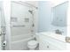 Bright bathroom featuring white tile, a shower-tub combo, and modern fixtures at 205 Sanora Blvd, Sanford, FL 32773