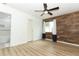 Well-lit bedroom with wood-look floors, ceiling fan and a wood accent wall at 205 Sanora Blvd, Sanford, FL 32773