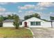 Charming single-story home featuring a red front door, white exterior, and a well-maintained front yard at 205 Sanora Blvd, Sanford, FL 32773