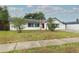 Street view of single-story home featuring a red front door, white exterior, and a partially shaded front yard at 205 Sanora Blvd, Sanford, FL 32773