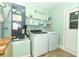 Functional laundry room with modern washer and dryer, shelving, and storage space at 205 Sanora Blvd, Sanford, FL 32773
