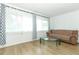 Bright living room featuring light wood floors, sheer curtained windows, and comfortable furniture at 205 Sanora Blvd, Sanford, FL 32773