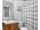 The bathroom has wood cabinet below a single sink and features a tiled shower/tub with patterned shower curtain at 2117 Stone Abbey Blvd, Orlando, FL 32828