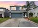 Charming two-story home featuring a two-car garage, well-manicured lawn and a lovely palm tree in the front yard at 2117 Stone Abbey Blvd, Orlando, FL 32828