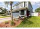 Beautiful home featuring a two-car garage, well-manicured lawn, a palm tree, and a vibrant red front door at 2117 Stone Abbey Blvd, Orlando, FL 32828