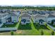 Aerial view of the property with a lush green lawn, partial fence, and community amenities at 2304 Mystic Maze Ln, Clermont, FL 34715