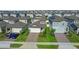 Aerial view of a residential street showcasing well-manicured lawns and brick paved driveways at 2304 Mystic Maze Ln, Clermont, FL 34715