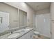 Bright bathroom features a double vanity with a granite countertop and white cabinets at 2304 Mystic Maze Ln, Clermont, FL 34715