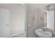 Bathroom area with a pedestal sink, large mirror, and doorway leading to another room at 2304 Mystic Maze Ln, Clermont, FL 34715