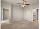 Bright bedroom features neutral carpet, a ceiling fan, and access to an ensuite bathroom for added convenience at 2304 Mystic Maze Ln, Clermont, FL 34715
