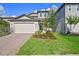 Charming two-story home featuring a brick driveway, well-manicured lawn, and attached two-car garage at 2304 Mystic Maze Ln, Clermont, FL 34715