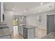 Modern kitchen island with granite countertops, stainless steel appliances, and a view of the living area at 2304 Mystic Maze Ln, Clermont, FL 34715