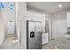 Modern kitchen with stainless steel appliances, white cabinetry, and granite countertops, seamlessly connected at 2304 Mystic Maze Ln, Clermont, FL 34715