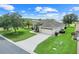 Elevated view of a meticulously kept home and yard with a long driveway and lush lawn at 27401 Pine Straw Rd, Leesburg, FL 34748