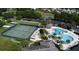 Aerial view of community amenities with tennis courts, pool, cabana, and lush greenery at 27401 Pine Straw Rd, Leesburg, FL 34748