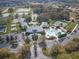 Comprehensive aerial view of a community featuring a clubhouse, pool, tennis courts, and ample parking at 27401 Pine Straw Rd, Leesburg, FL 34748
