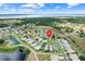 Stunning aerial view of neighborhood with lush landscaping near tranquil lake and with pinpoint home location at 27401 Pine Straw Rd, Leesburg, FL 34748