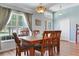 A dining area with hardwood floors, natural lighting from a window, and a decorative chandelier at 27401 Pine Straw Rd, Leesburg, FL 34748