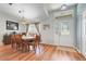 Dining area with vaulted ceiling, hardwood floors, elegant lighting, and a front door view at 27401 Pine Straw Rd, Leesburg, FL 34748