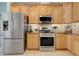 Stainless steel appliances and wooden cabinets are features of this functional and stylish kitchen at 27401 Pine Straw Rd, Leesburg, FL 34748