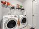 Functional laundry room with two front load washers, a shelf, and a door for convenience at 27401 Pine Straw Rd, Leesburg, FL 34748