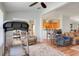 Open living room showcasing hardwood floors, ceiling fan, multiple seating options, and seamless flow to other areas at 27401 Pine Straw Rd, Leesburg, FL 34748