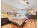 Comfortable main bedroom with wood floors, a king-sized bed, a dresser, and a ceiling fan at 27401 Pine Straw Rd, Leesburg, FL 34748