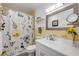 Bright bathroom featuring floral shower curtain, vanity, and a well-lit mirror at 2750 Ocean Shore Blvd # 350, Ormond Beach, FL 32176