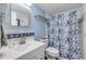 Bathroom featuring blue walls, decorative tile accent, shower with leaf pattern curtain, and a sink at 2750 Ocean Shore Blvd # 350, Ormond Beach, FL 32176