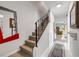 Bright entryway with wood stairs, iron railing, decorative mirrors, and access to living area at 2750 Ocean Shore Blvd # 350, Ormond Beach, FL 32176