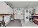 Bright laundry room includes modern stacked washer and dryer with extra storage cabinets and gray flooring at 2750 Ocean Shore Blvd # 350, Ormond Beach, FL 32176