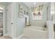 Elegant bathroom with a soaking tub, decorative window treatments, and stylish fixtures at 2842 Balforn Tower, Winter Garden, FL 34787