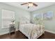 Cozy bedroom features a white metal bed frame, wood floors, a ceiling fan, and bright natural light at 2842 Balforn Tower, Winter Garden, FL 34787