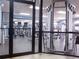 View of a fully-equipped gym with treadmills and weight machines through a glass-enclosed room at 2842 Balforn Tower, Winter Garden, FL 34787