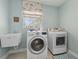 Laundry room with modern washer and dryer, utility sink, window, and blue and pink decor at 2842 Balforn Tower, Winter Garden, FL 34787
