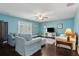 Cozy living room with plush armchairs, a ceiling fan, and doors that invite natural light at 2842 Balforn Tower, Winter Garden, FL 34787