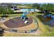 Community playground area with slides, swings, and benches enclosed by black fencing at 2842 Balforn Tower, Winter Garden, FL 34787