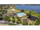 An aerial view of a beautiful pool with palm trees, a playground, and a large lake in the background at 2842 Balforn Tower, Winter Garden, FL 34787