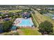 Aerial view of a community pool with lounge chairs and umbrellas, surrounded by lush greenery and neighborhood homes at 2842 Balforn Tower, Winter Garden, FL 34787