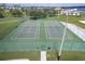 Aerial view of fenced tennis courts with manicured landscaping and seating for spectators at 2842 Balforn Tower, Winter Garden, FL 34787