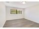 Neutral bedroom with wood-look floors and natural light from a large window at 2927 Ahern Dr, Orlando, FL 32817