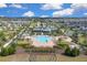 Wide aerial perspective of the community, highlighting the pool, landscaping, and surrounding residences at 3017 Ambersweet Pl, Clermont, FL 34711