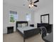 Bright bedroom with a ceiling fan, two windows, and a large black bed at 3017 Ambersweet Pl, Clermont, FL 34711