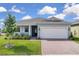 Charming single-story home featuring a manicured lawn and brick-paved driveway leading to an attached two-car garage at 3017 Ambersweet Pl, Clermont, FL 34711