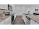 Modern kitchen featuring granite countertops, white cabinets, stainless steel appliances, and hardwood floors at 3017 Ambersweet Pl, Clermont, FL 34711